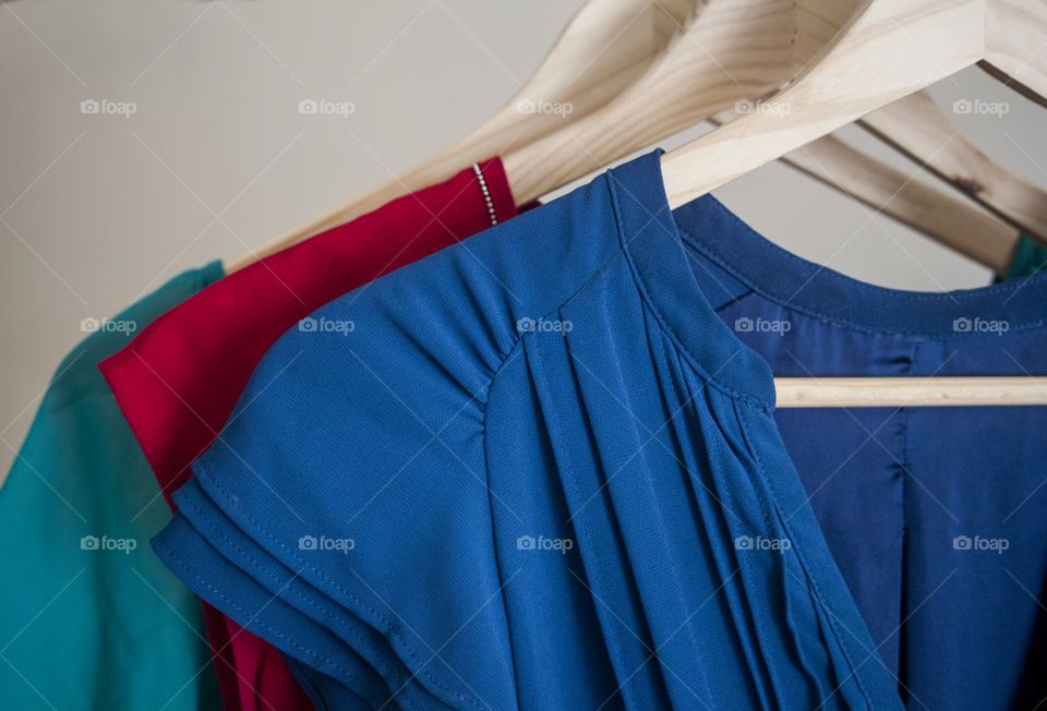 Close up of bright colored clothes on a rack