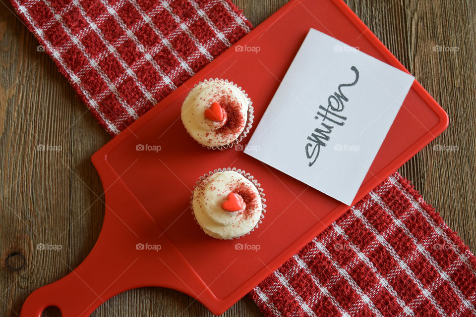 Red velvet cupcakes with Valentine's day sentiments on wood background