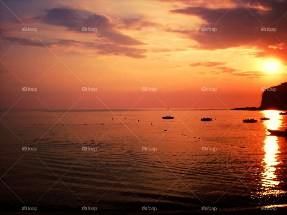 Clouds on the boats at    Sunset over Praia ( Italy ).