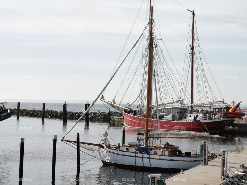 Segelschiff im Hafen vor altem Zweimaster