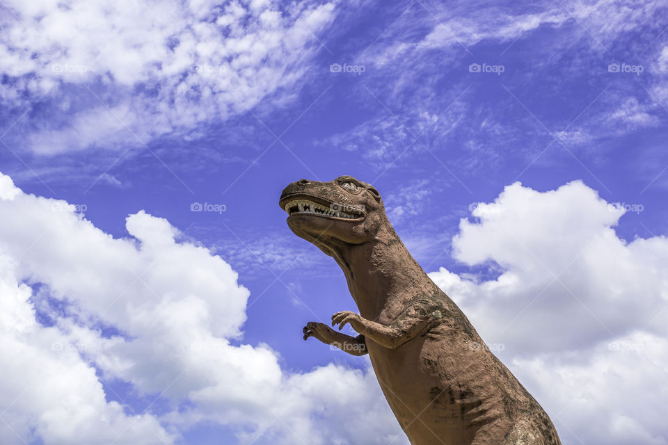 Dinosaur statue with blue sky