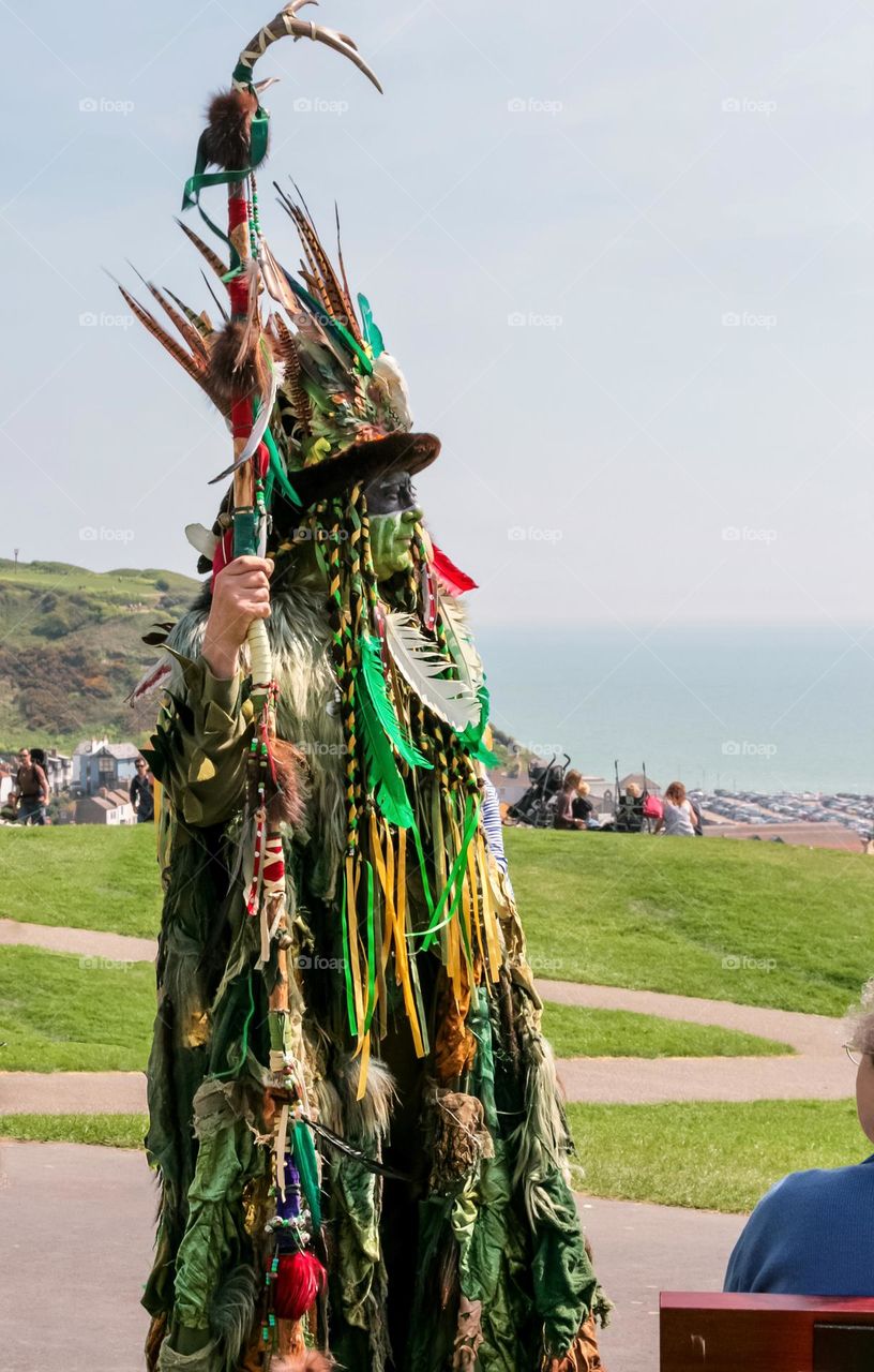 A man dressed up in green man attire to celebrate Beltane by the south coast of England 