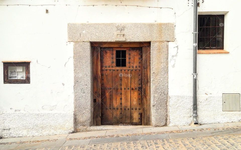 Old wooden front door and granite doorway. Traditional Spanish architecture. Galicia, Spain.