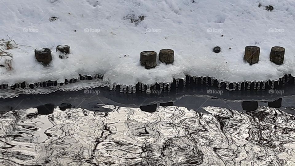 incredible ice and winter picture on the river shore - like a graphic linear picture, nearly black and white