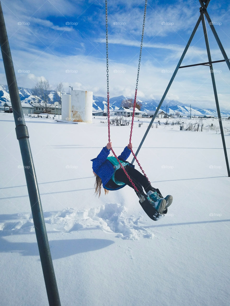 Girl on swing in snowy winter