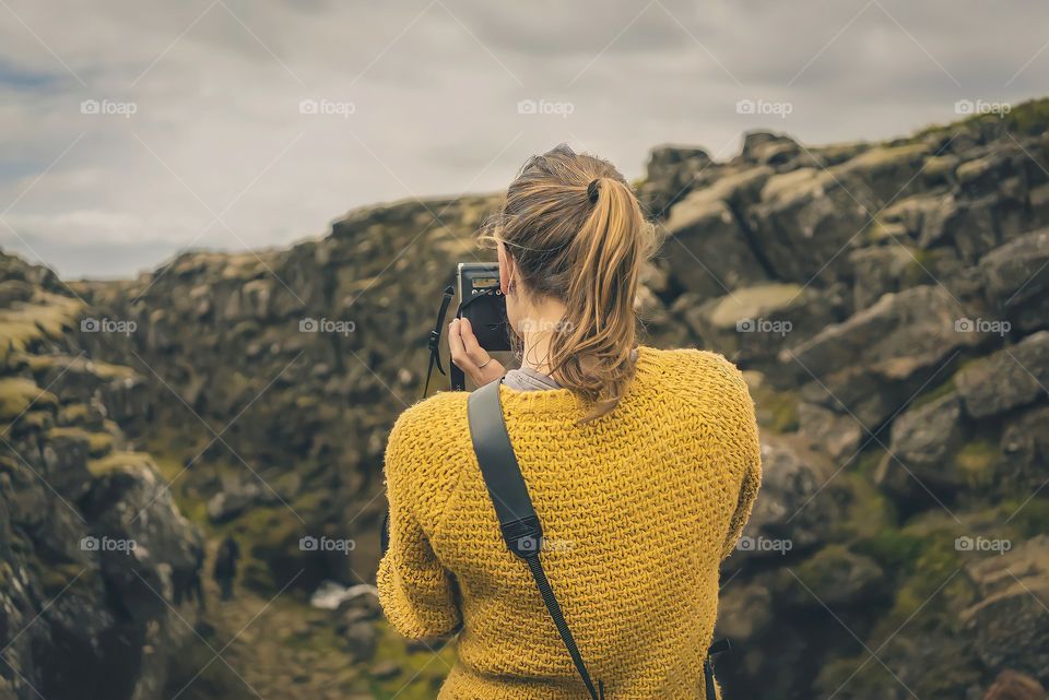 Back side view of woman photographer
Rear view of young blonde woman in yellow sweater taking picture of mountains.