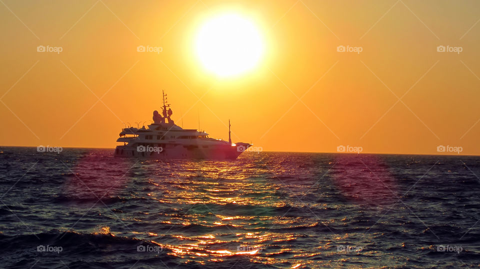 sunset ship greece mykonos island. rushing to catch the sundown