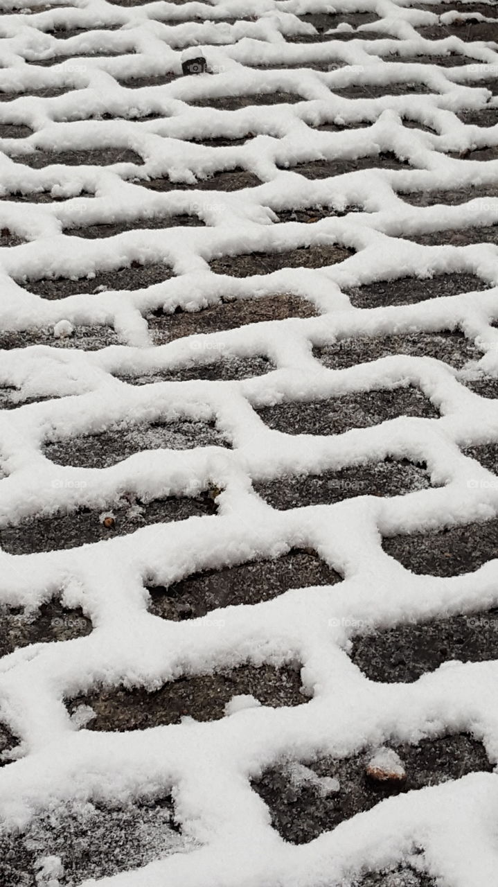 Snow on cobblestone sidewalk