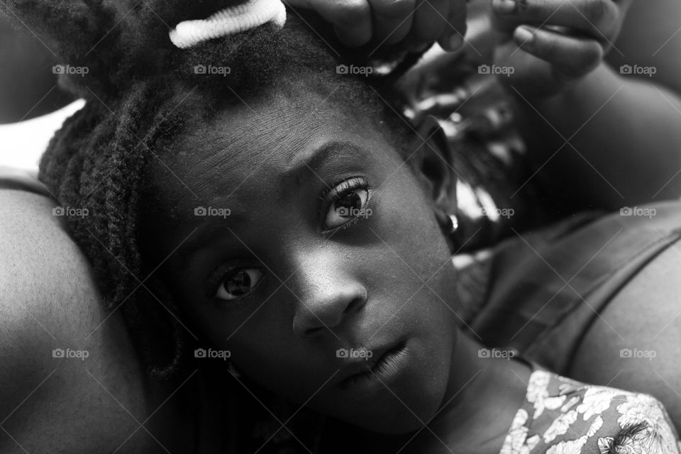 A child getting her hair plaited
