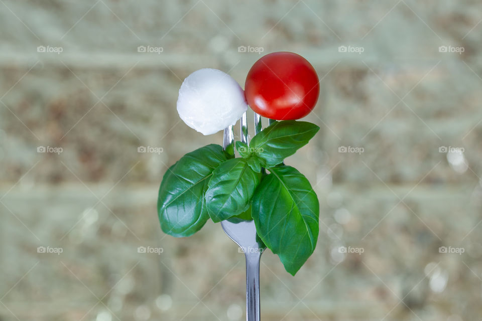 tomato, mozzarella and basil on a fork