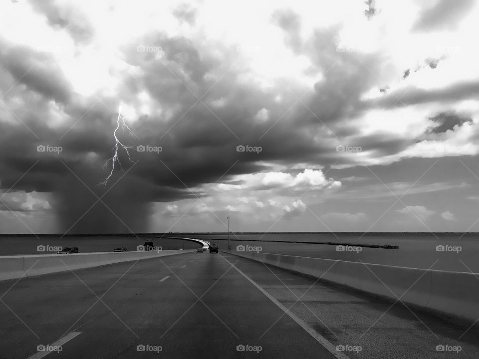 Crossing over a bridge driving to work with a dramatic lightning storm approaching.