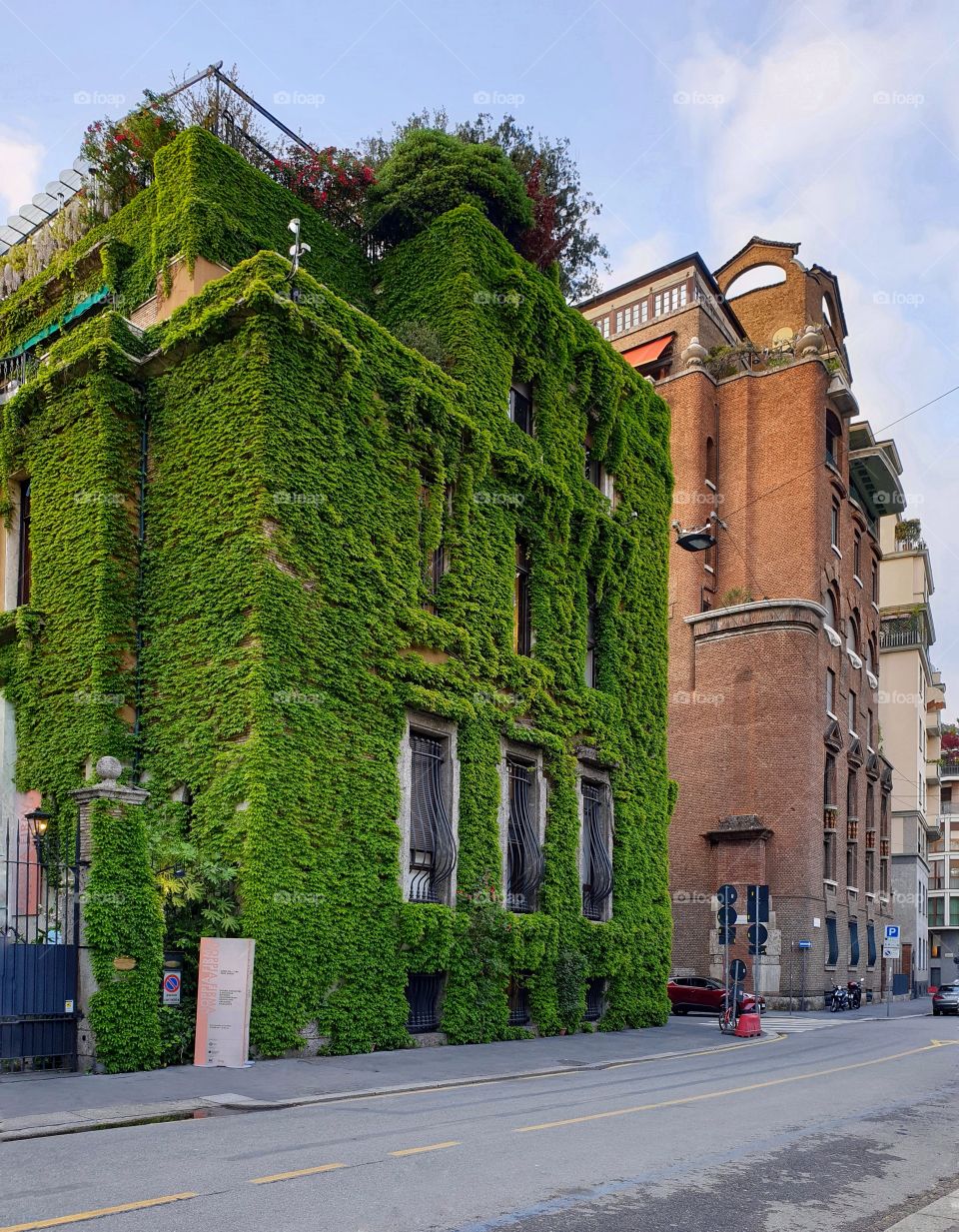 Villa Mozart covered with green vegetation. Street in Milan, Italy