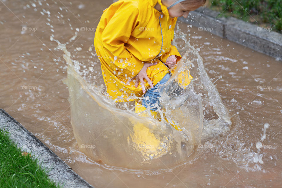 Kid jumping in the puddle