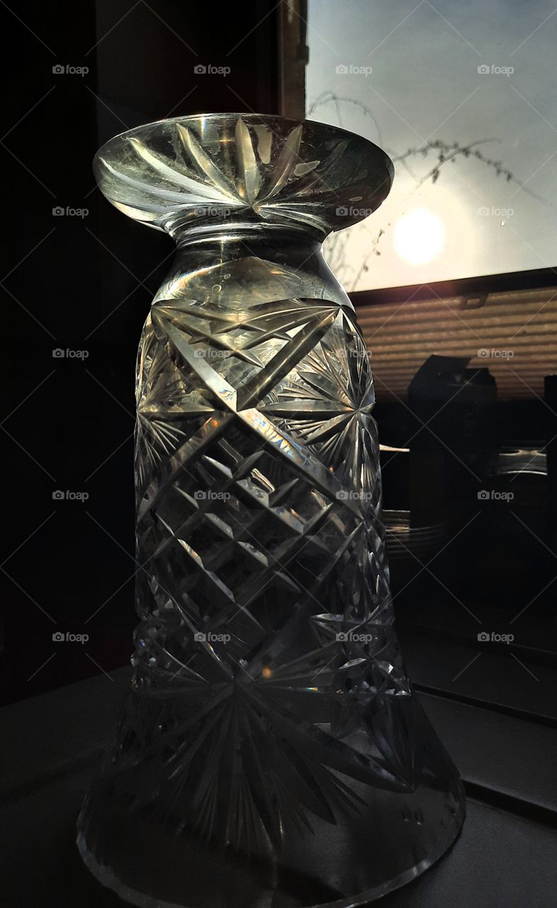 sunshine  illuminating crystal vase standing on a windowsill