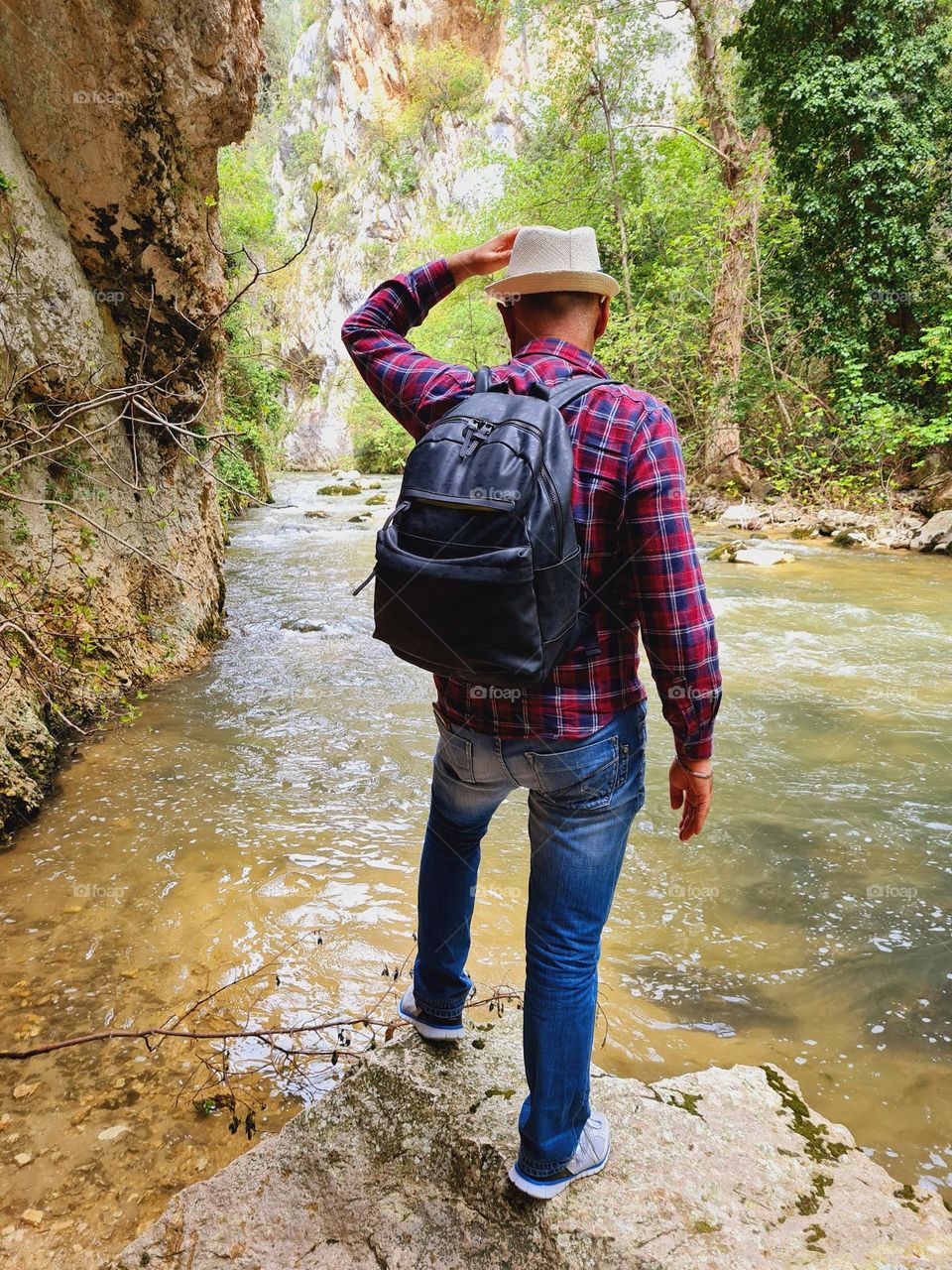 Shouldering hiker take a trip to the river in spring