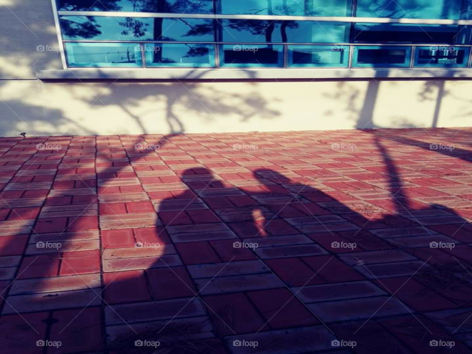 a shadow of a mother  thats tapping the back of her daughter as a sign of comfort.