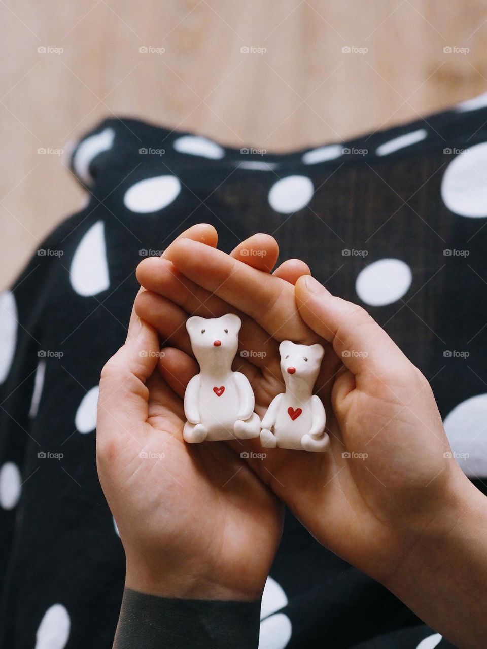 Cute little white ceramic bears on a hands