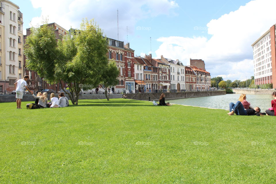 People chillin' on the grass in Lille, France. Summer next to the lake.