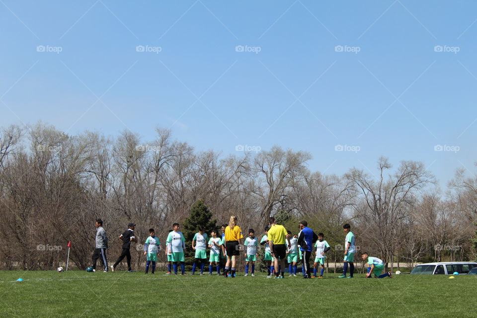 Kids playing soccer in a beautiful spring day