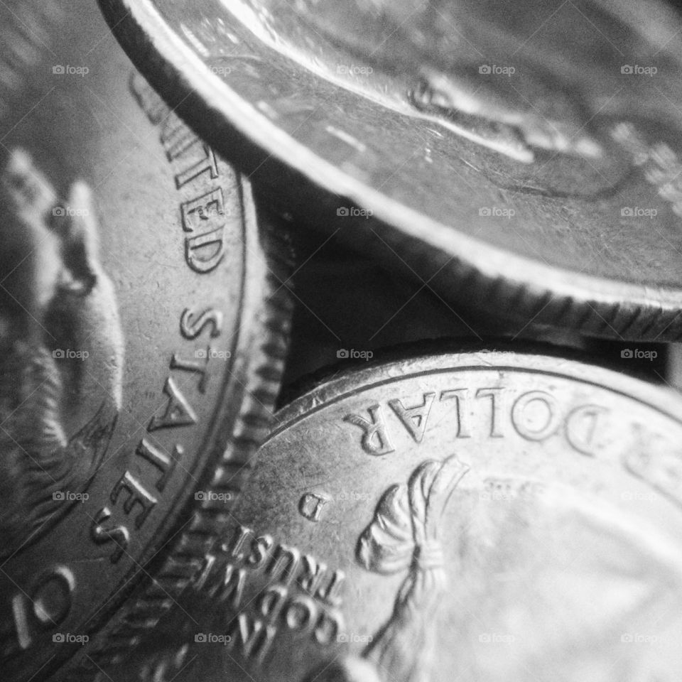 Detail black and white macro shot of 3 coins stacked in a pyramid.