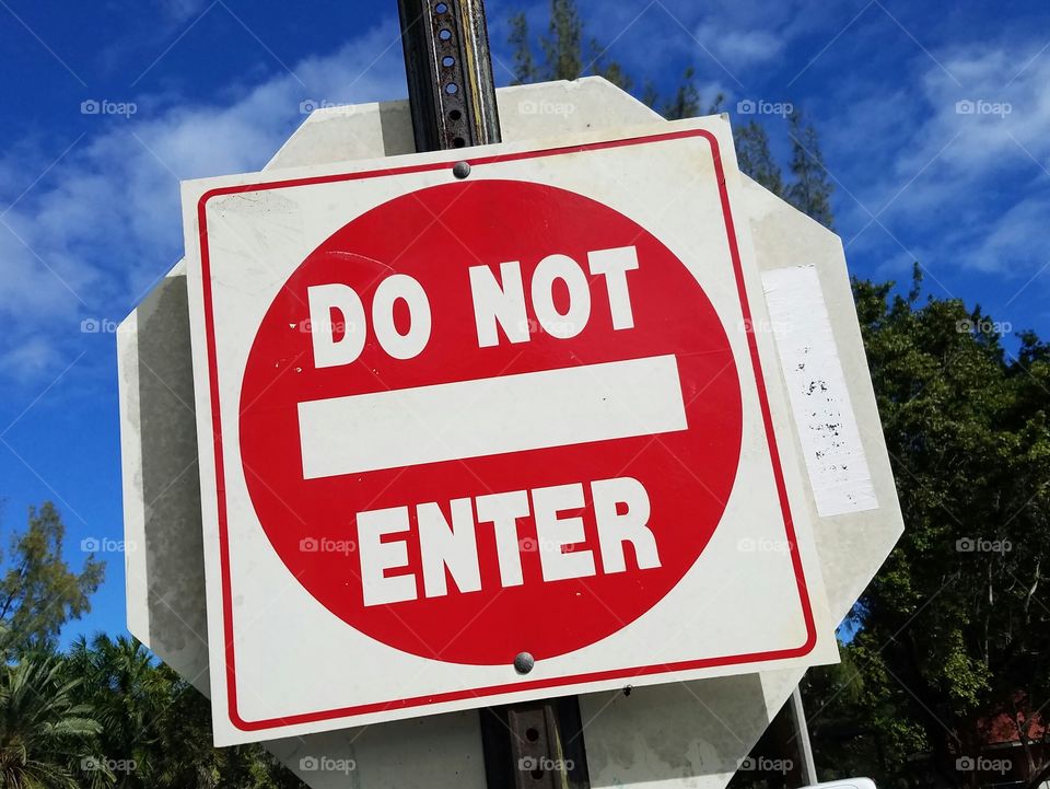 foreboding red do not enter sign against an inviting blue sky.
