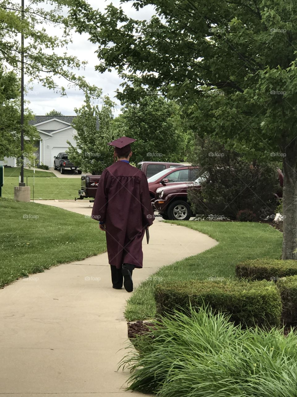 Graduate walking on sidewalk