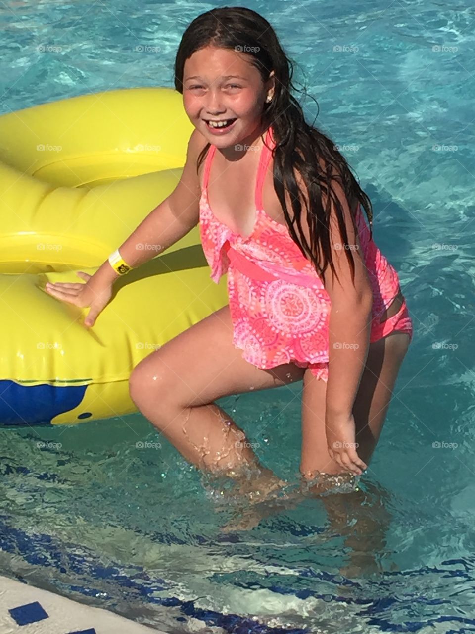 Smiling girl standing in pool