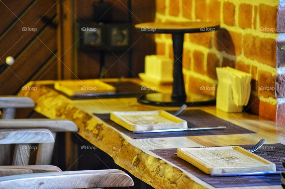 cafe interior in loft style with paintings and wooden interior items . bar counter made of service t wooden plates.