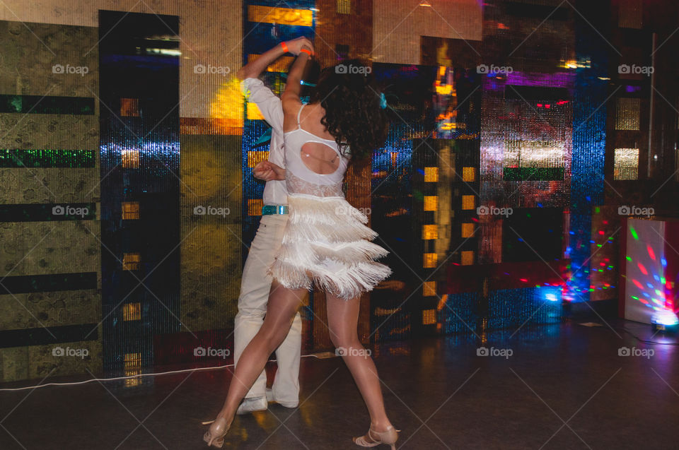 Couple dancing on the stage, white costumes 