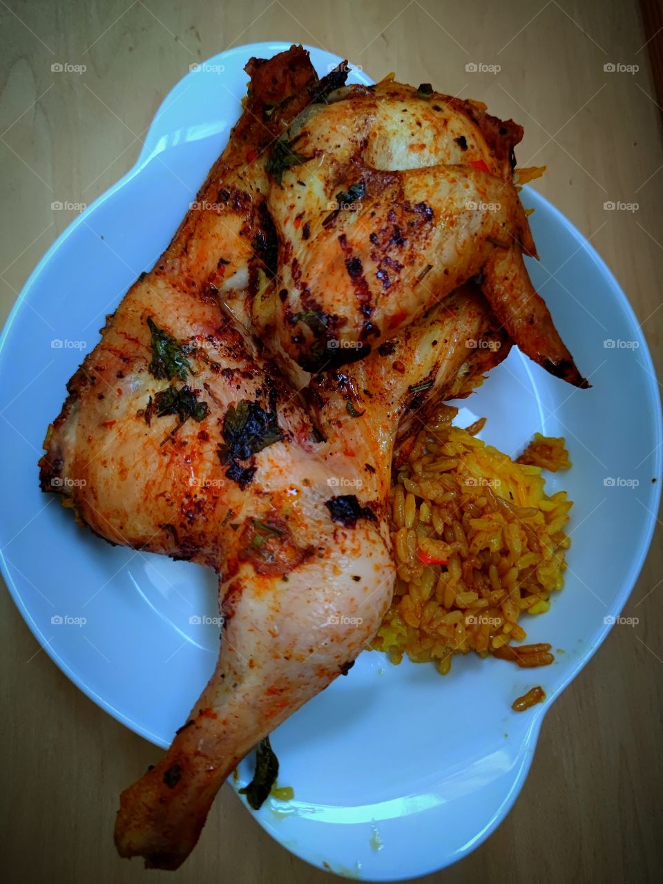 plate with ready meals.  view from above.  Rice with saffron and half a chicken with spices.