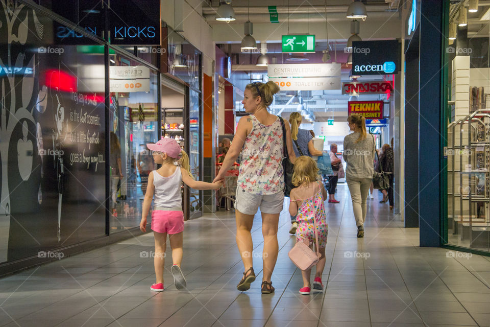 Mom and her two young girls at a shopping mall in Mobilia Malmö Sweden.