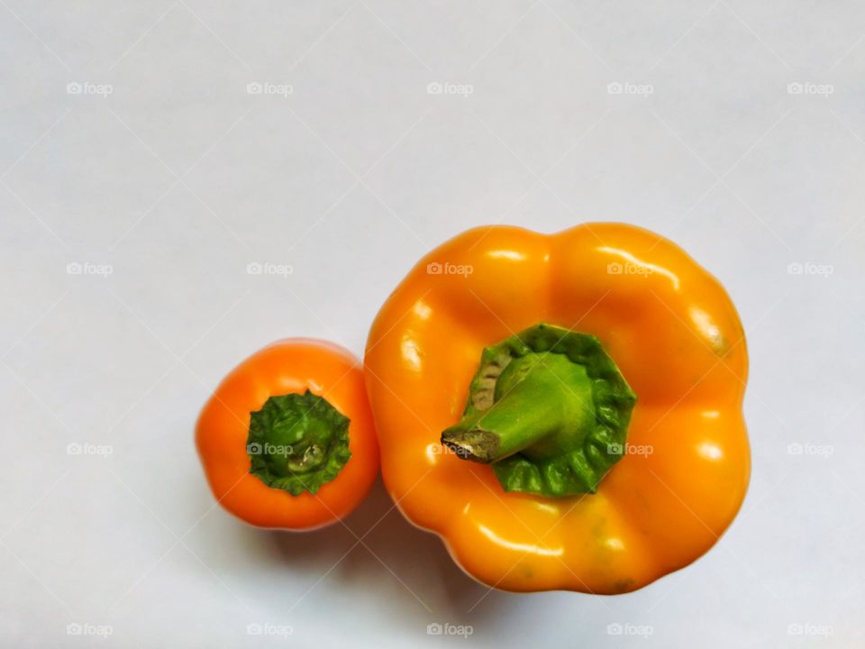 top view of mother pepper with her mini son from closeup on white background , minimal concept