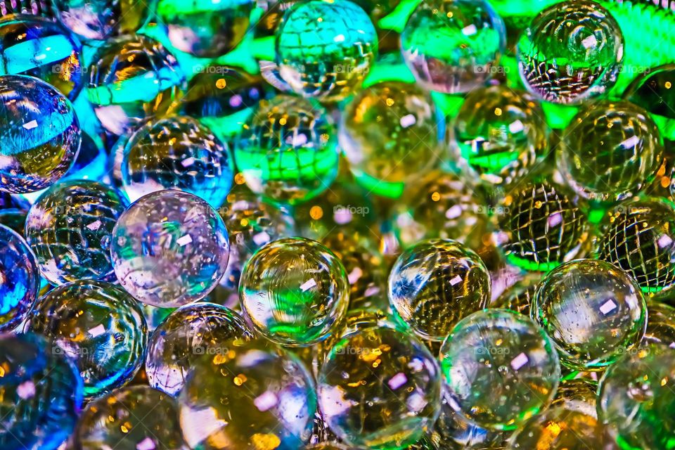 Colorful shiny glass marbles reflecting a rainbow of colors, closeup macro image 