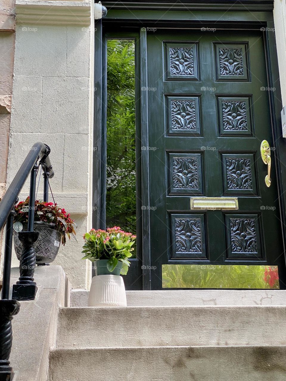 Dark green front door with decorative flowers. Manhattan New York. 