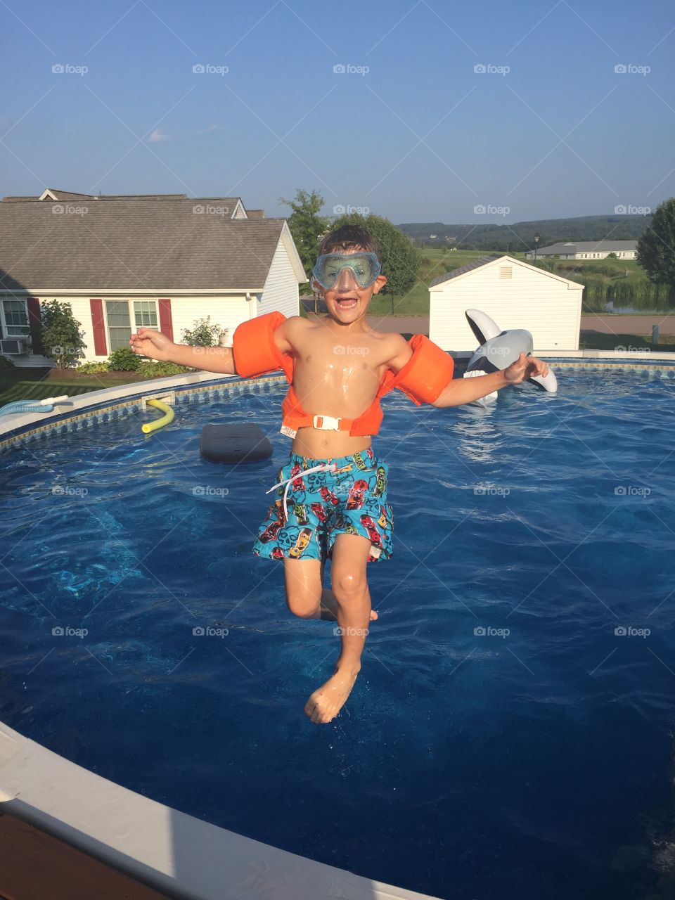 Happy boy jumping in swimming pool