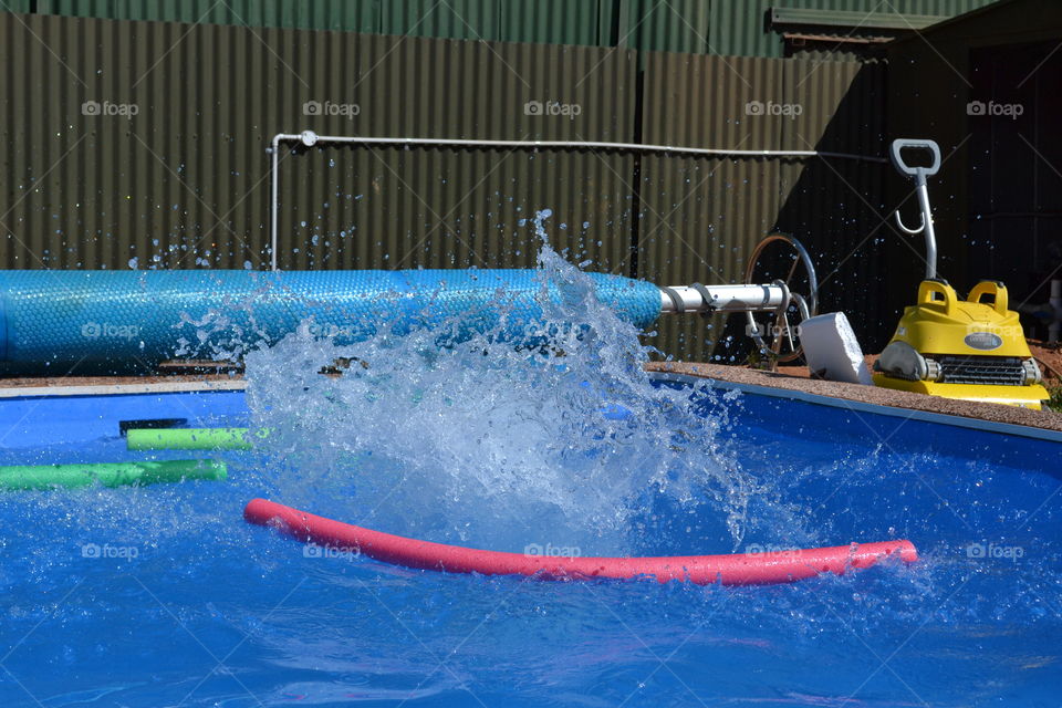 Big water splash in outdoor swimming pool