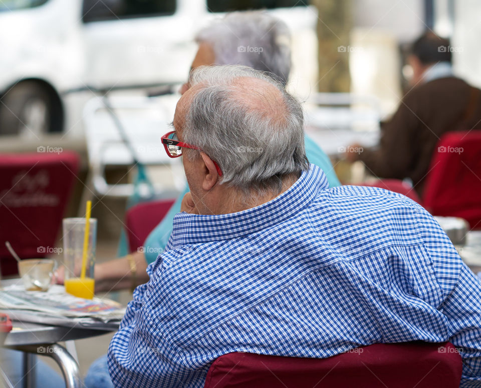 Elderly man with friends at an street cafe