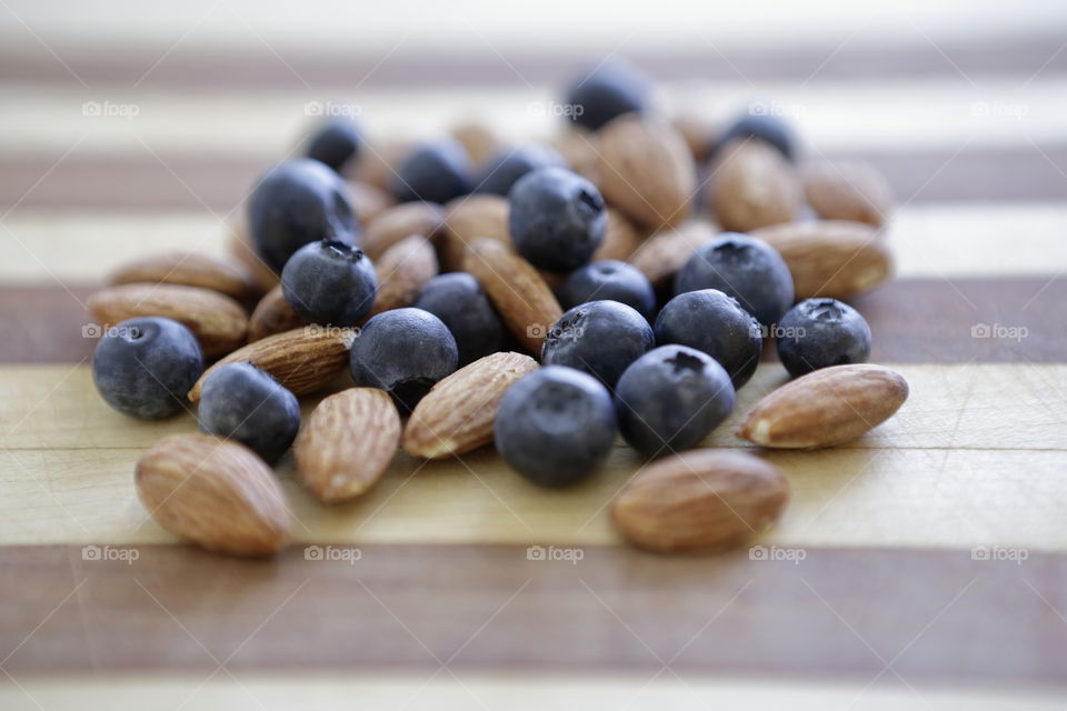 Blueberries and almonds on cutting board for a snack
