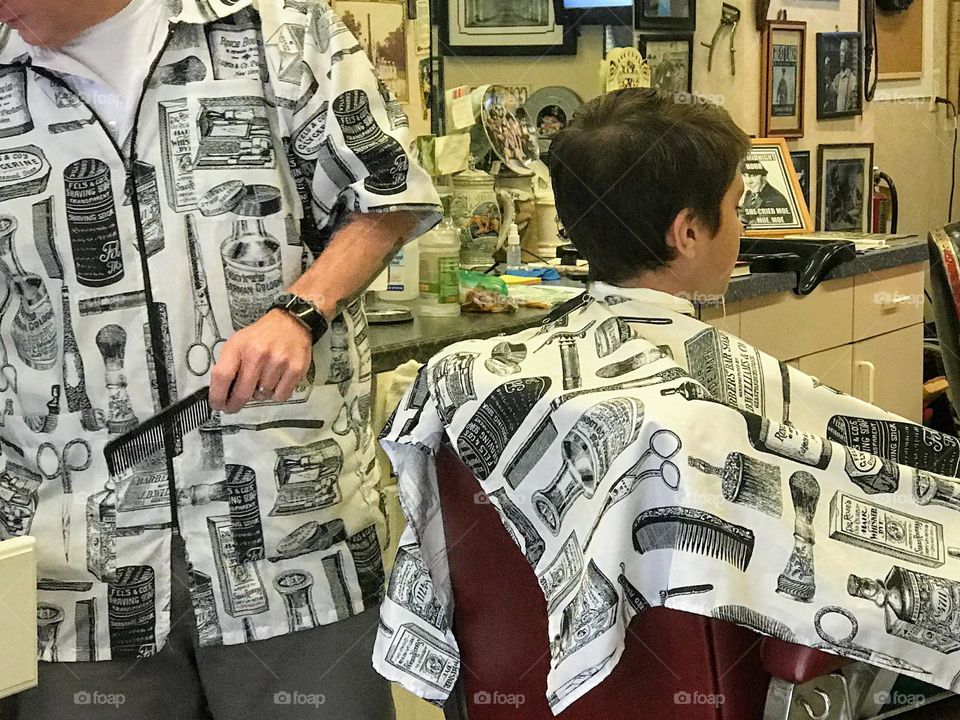 Boy getting hair cut in Barber shop 