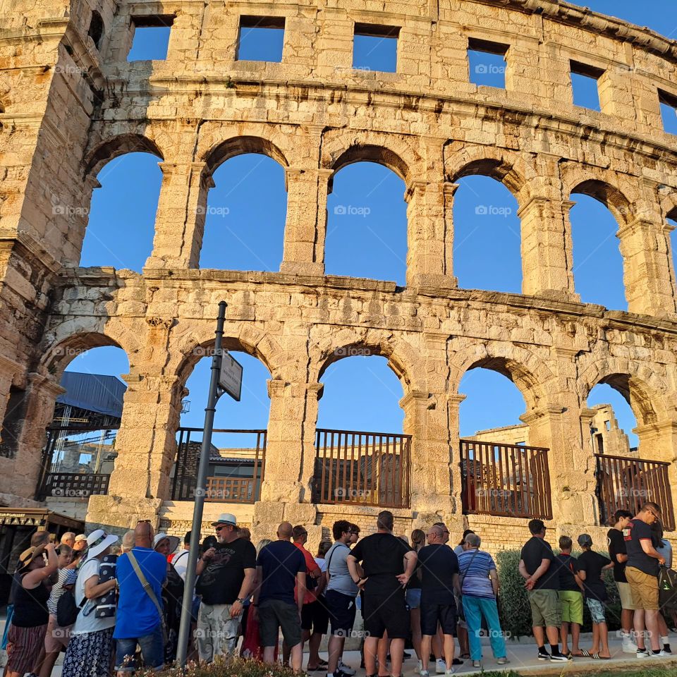 Amphitheatre ancient building Pula Croatia. People queing to go in summer evening