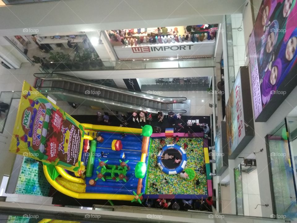 Having a little playground at the center of the mall can make parents spend all day at the mall because, kids just want to play.