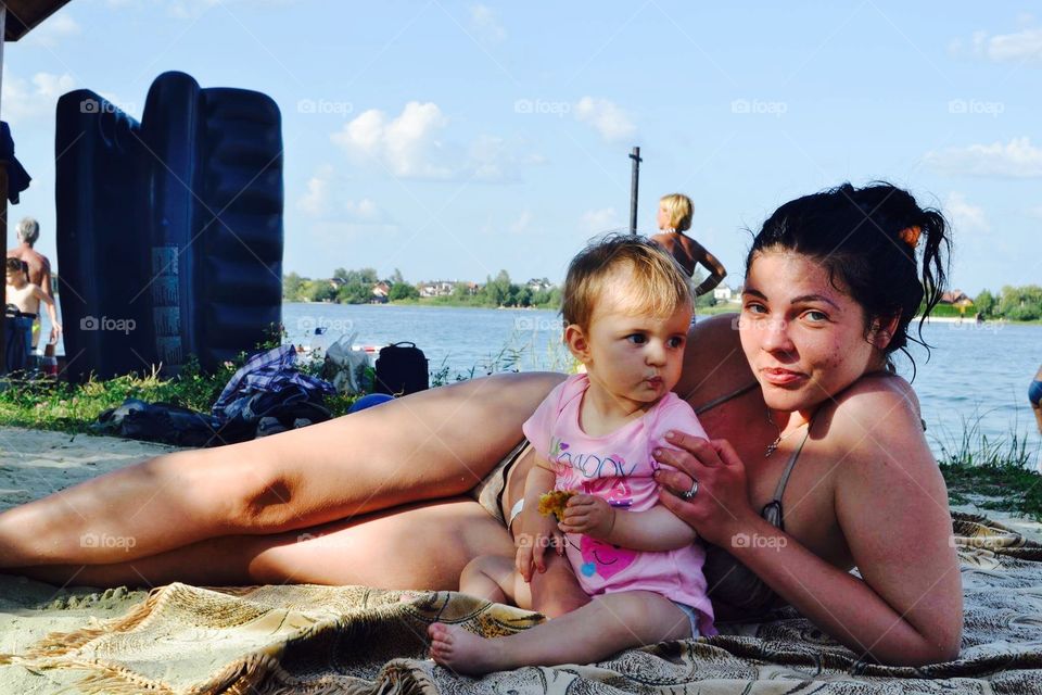 Baby and mother at the lake beach 