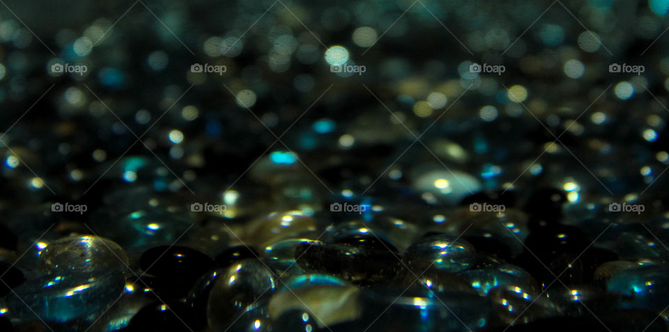 Colored glass pebbles in dark water