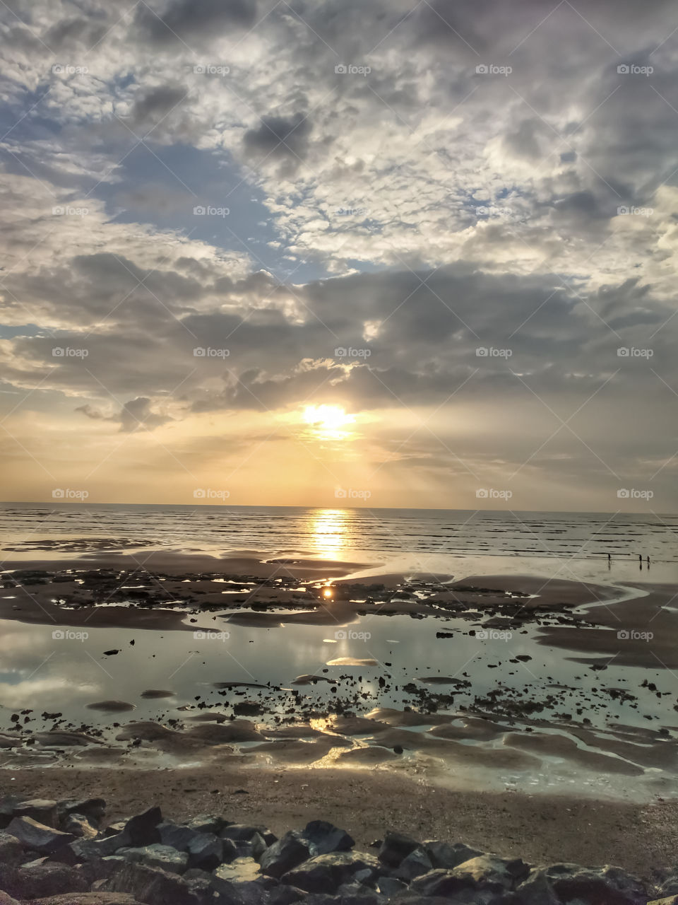 He watched the sunset at the horizon, spreading its largess into a grateful sky.