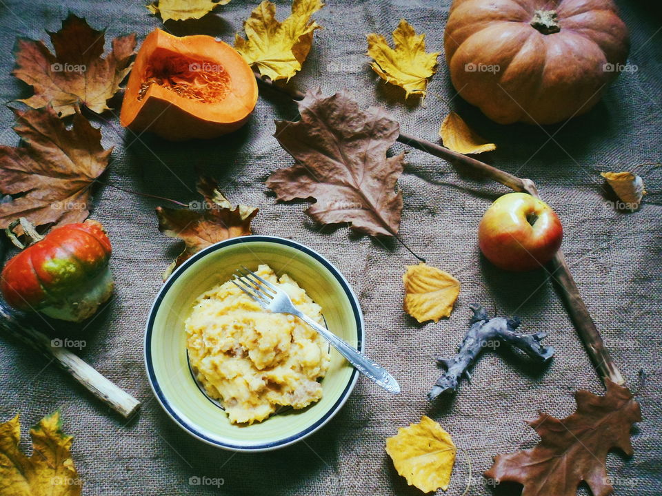 Mashed potatoes in a plate, autumn leaves and pumpkins