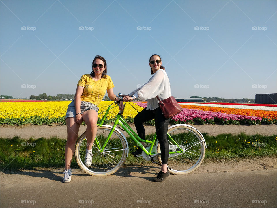 Girls on a bike with tulip fields behind