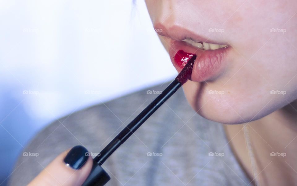 woman paints her lips