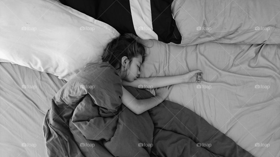 High angle view of a girl sleeping on bed