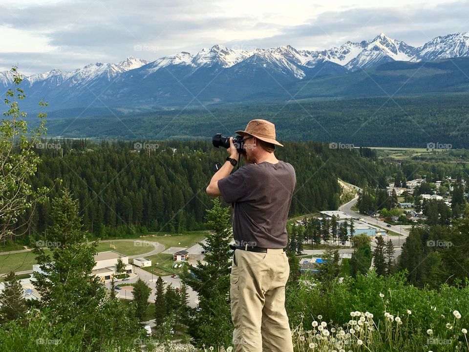 Male photographer shooting Mountain scene with DSLR camera Rocky Mountains canada 