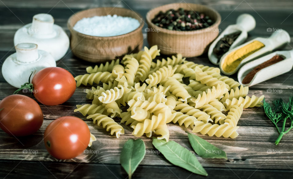 Raw pasta with ingredients and wooden accessories